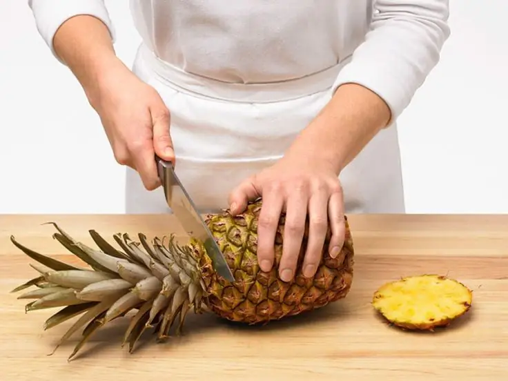 peeling a pineapple with a knife